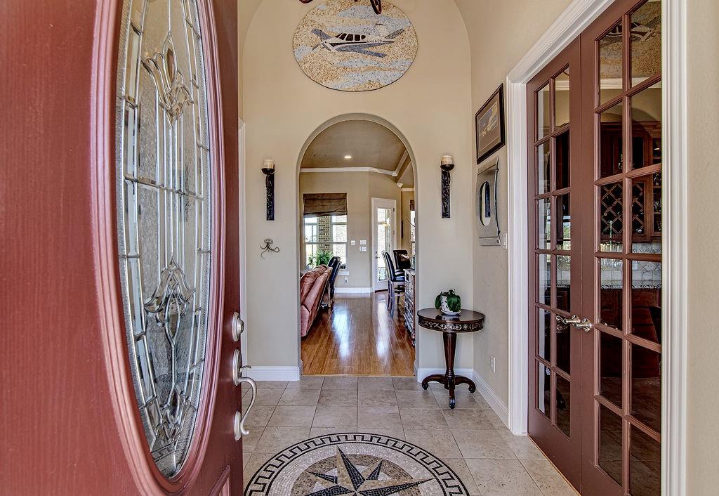 117 Citation Drive Cresson, TX 76035 - Photo 5 of 40 Foyer entrance with arched walkways, crown molding, light tile patterned floors, inlaid floor details, and french doors