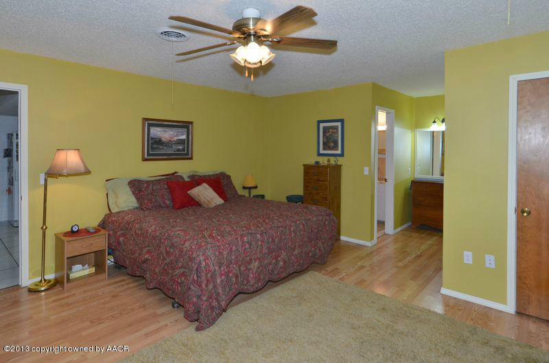 5111 Shield Drive Amarillo, TX 79110 - Photo 11 of 23 a spacious bedroom with a bed and a chandelier