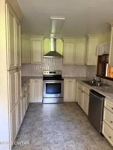 a kitchen with kitchen island granite countertop a stove a sink and a refrigerator