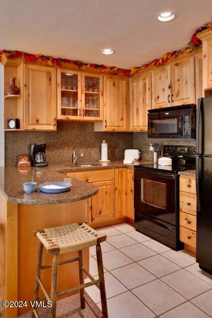 a kitchen with stainless steel appliances kitchen island granite countertop a stove top oven a sink dishwasher and cabinets with wooden floor