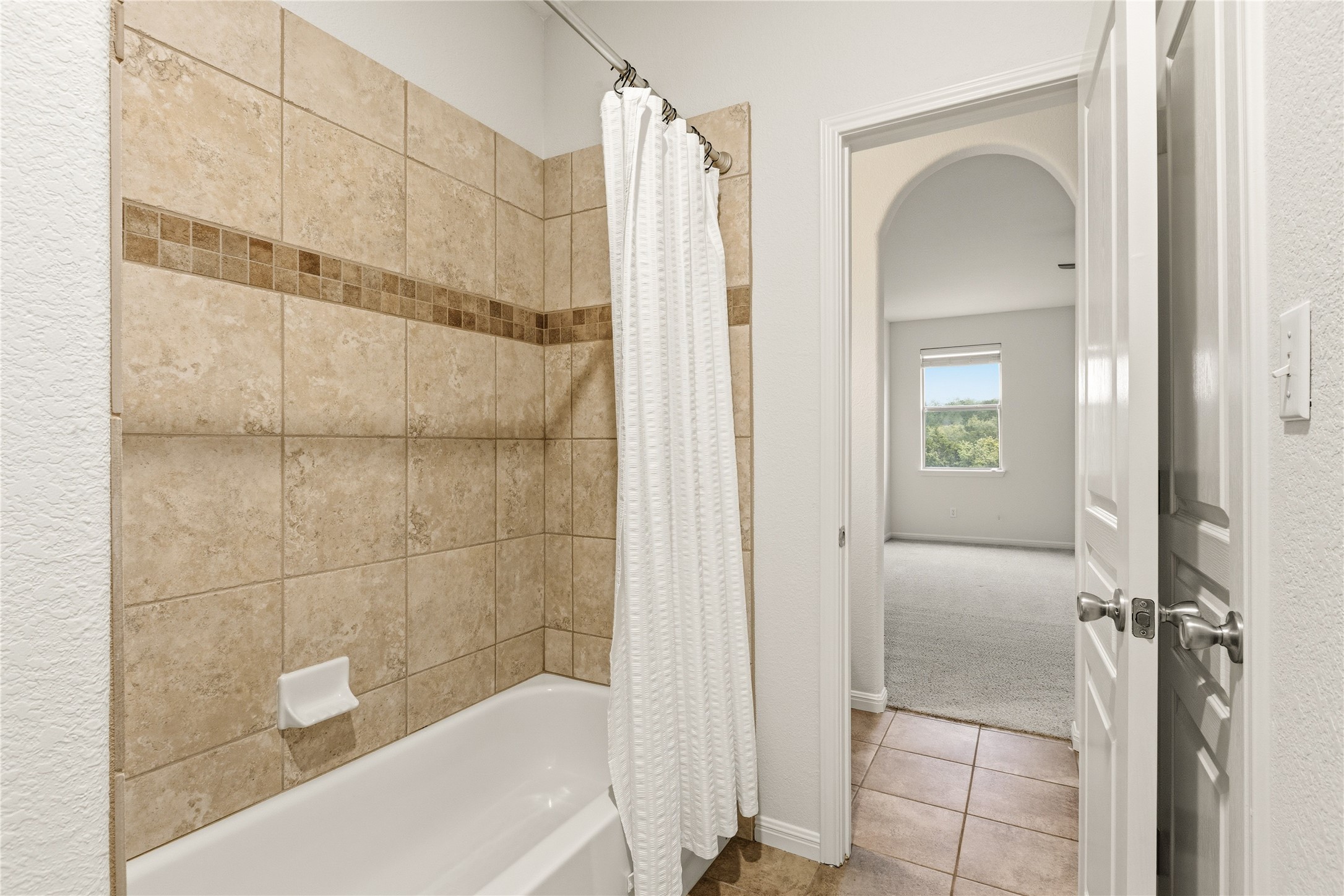 1432 Tom Sawyer Road Austin, TX 78737 - Photo 23 of 33 Functional bathroom features a tub with tiled surround, offering convenient access to an adjacent living space.