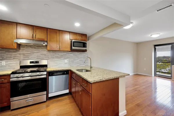 a kitchen with stainless steel appliances granite countertop a stove a sink and a microwave