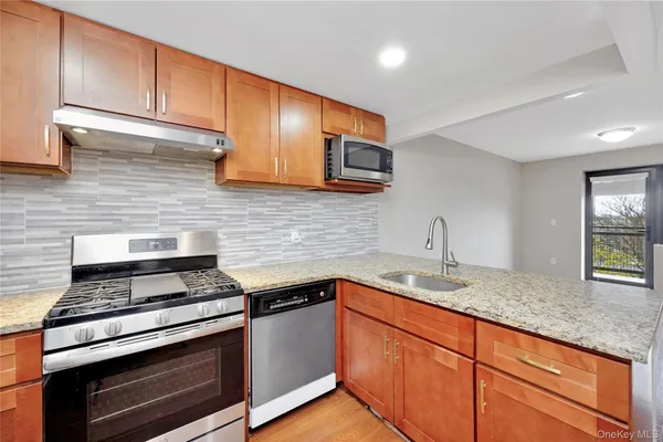 a kitchen with granite countertop cabinets stainless steel appliances and sink