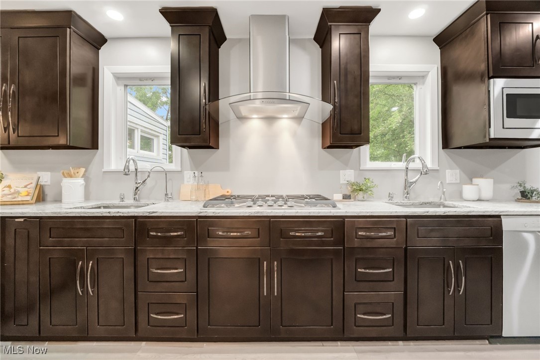 2524 Claver Road Cleveland, OH 44118 - Photo 19 of 50 Kitchen with wall chimney range hood, stainless steel appliances, a sink, dark brown cabinetry, and recessed lighting