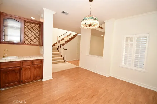 a living room with furniture kitchen view and a wooden floor