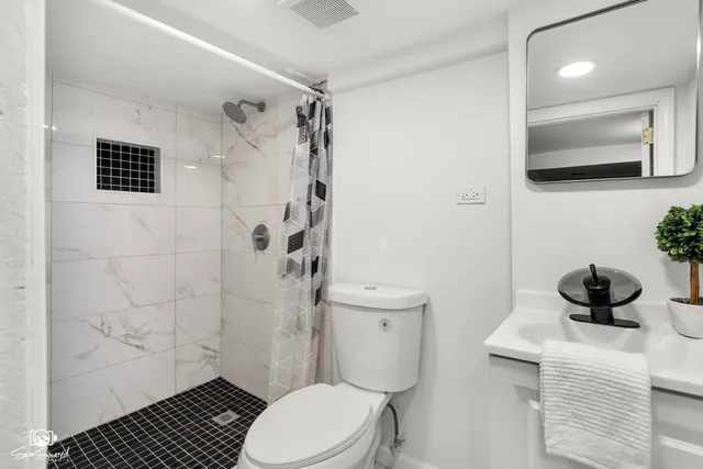 a bathroom with a toilet a sink and shower
