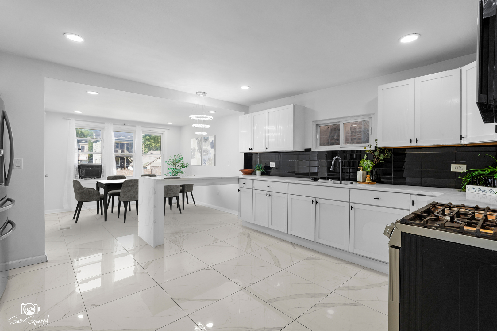 5636 South Carpenter Street Chicago, IL 60621 - Photo 5 of 27 a kitchen with stainless steel appliances kitchen island granite countertop a stove a sink a dining table and chairs