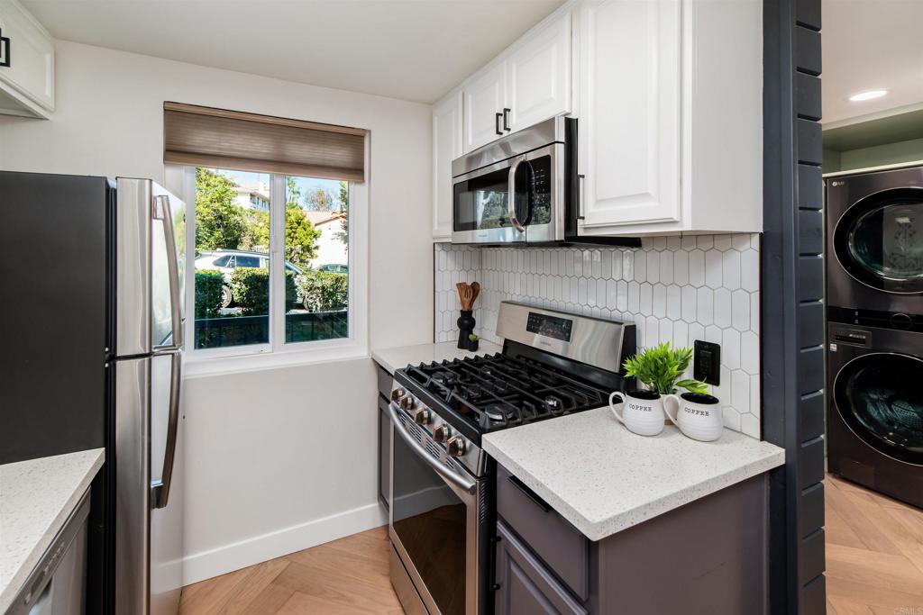 2349 Altisma Way, Unit B Carlsbad, CA 92009 - Photo 8 of 36 a kitchen with a stove a sink and a refrigerator