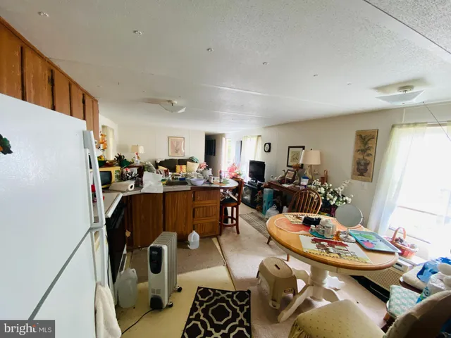 a living room with furniture kitchen view and a window