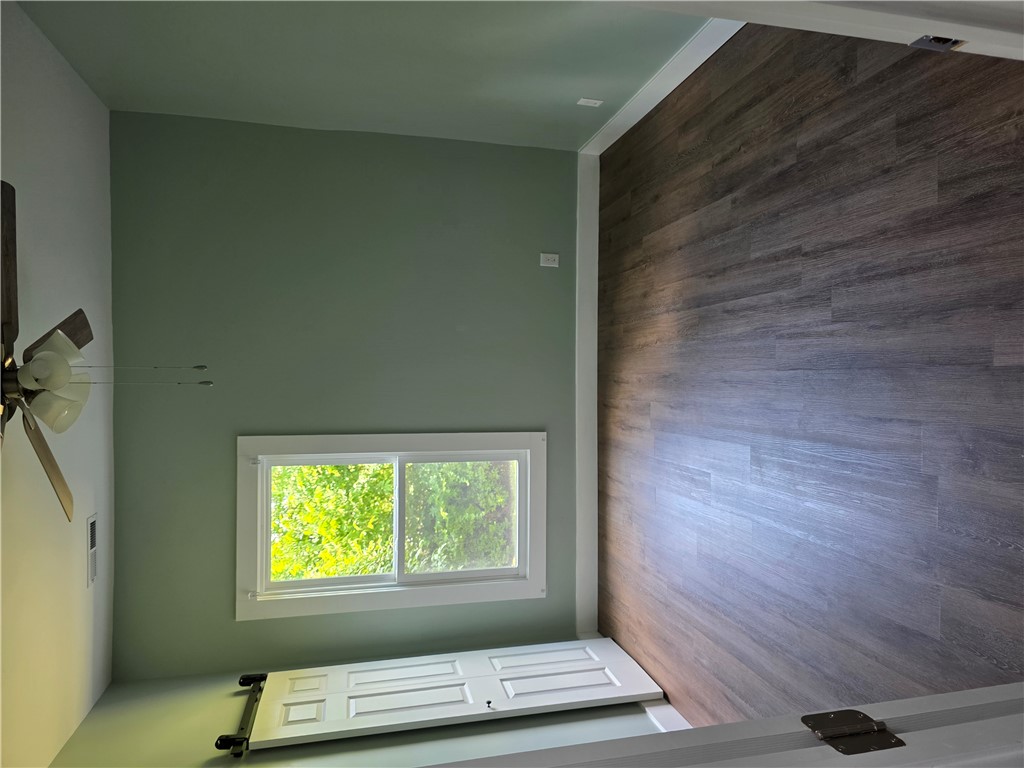 112 Simmons Street Anderson, SC 29625 - Photo 24 of 26 Natural light filters into a spacious room featuring high ceilings and rich wood flooring.