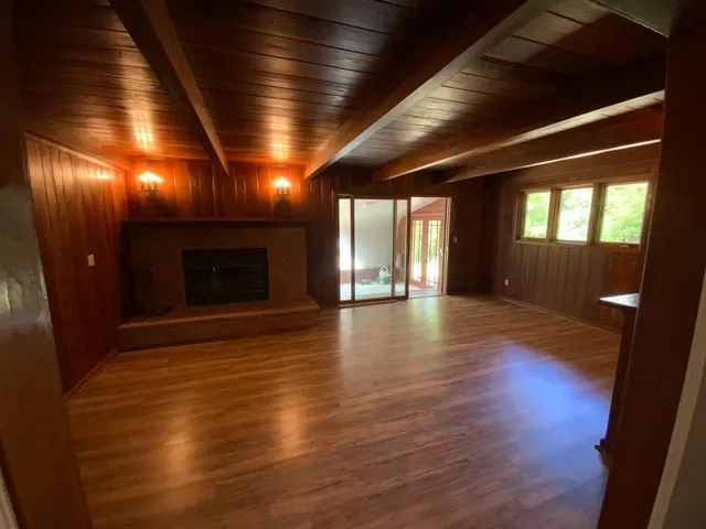 an empty room with wooden floor and fireplace