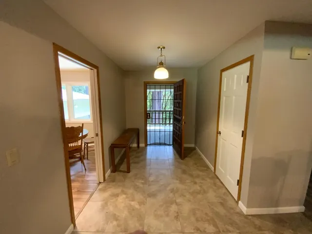 a hallway with furniture and a chandelier
