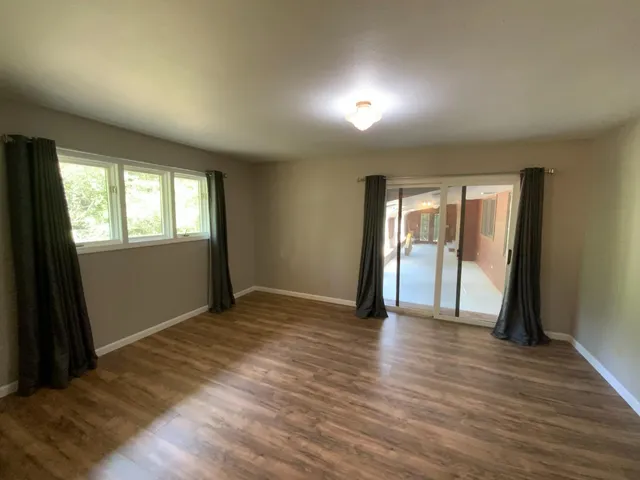 an empty room with wooden floor and a window