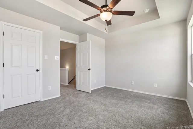 an empty room with closet and a chandelier fan