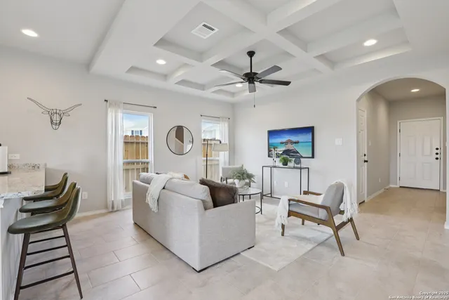 a living room with furniture a rug and a ceiling fan