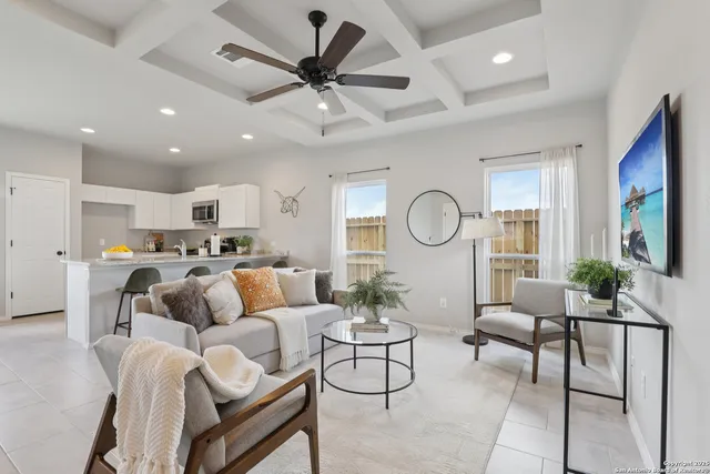 a living room with furniture kitchen view and a large window