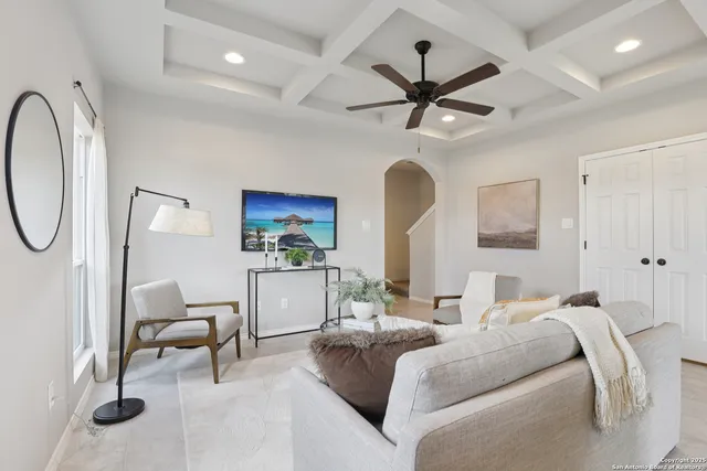 a living room with furniture a ceiling fan and a rug