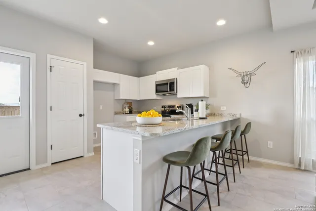 a kitchen with stainless steel appliances granite countertop a sink and a refrigerator