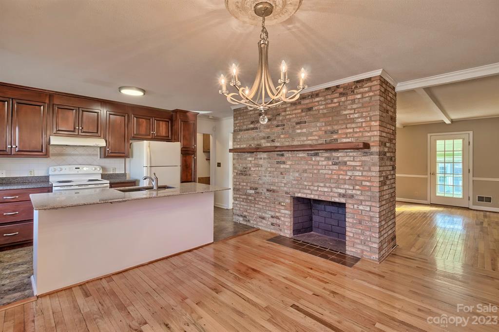 117 State Rd S-29-221 Kershaw, SC 29067 - Photo 13 of 28 a open kitchen view with fireplace and wooden floor