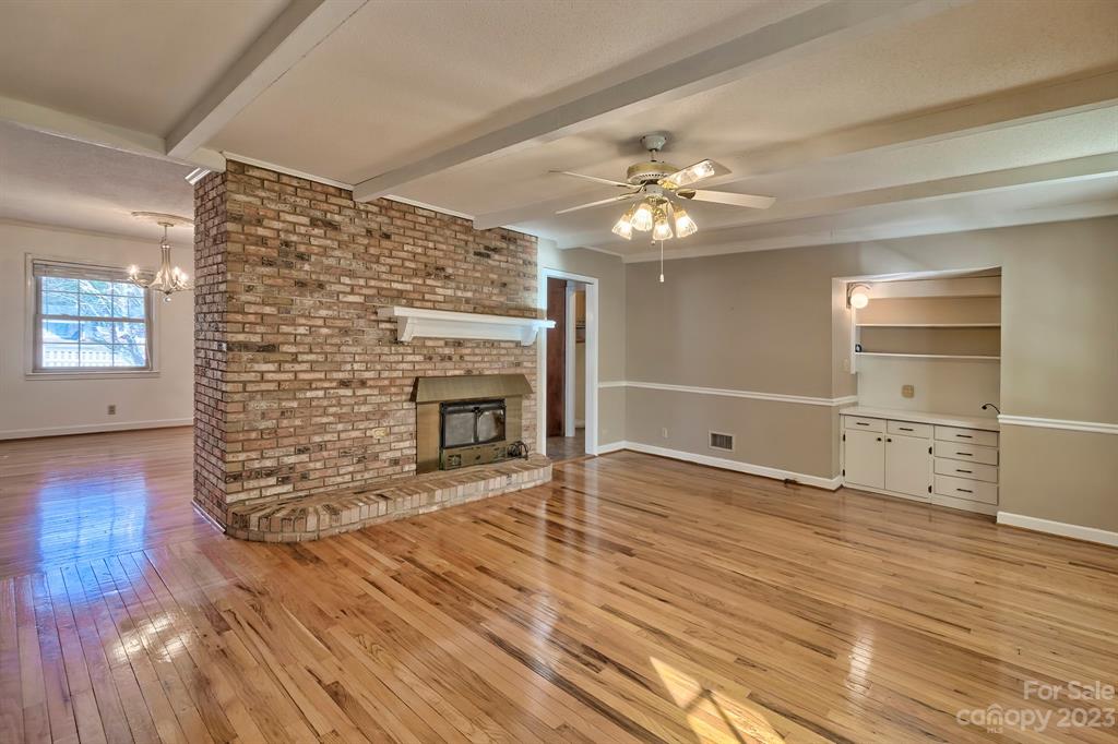 117 State Rd S-29-221 Kershaw, SC 29067 - Photo 16 of 28 a view of a livingroom with a fireplace a chandelier and wooden floor
