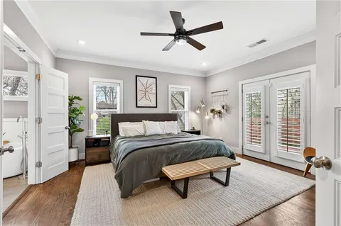 a bedroom with a bed a dresser and a chandelier
