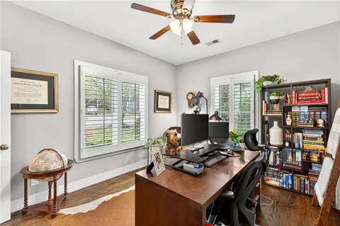 a view of a workspace with furniture and a window