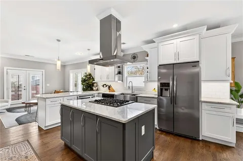 a kitchen that has a sink stainless steel appliances a counter space and wooden floor