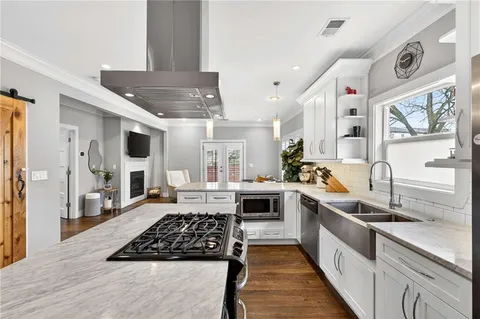 a kitchen with stainless steel appliances granite countertop a sink stove and refrigerator