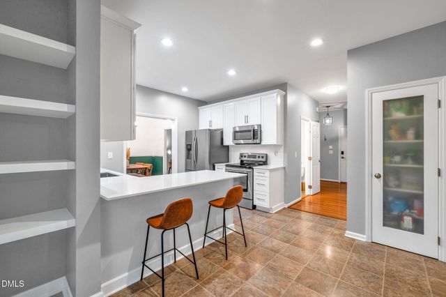 a view of kitchen with stainless steel appliances refrigerator stove microwave and cabinets