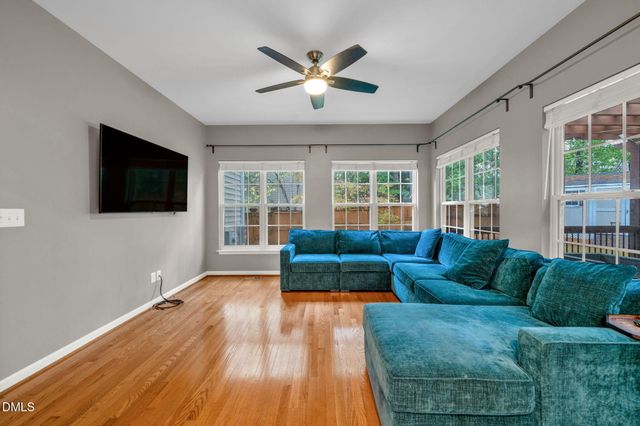 a living room with furniture ceiling fan and a flat screen tv
