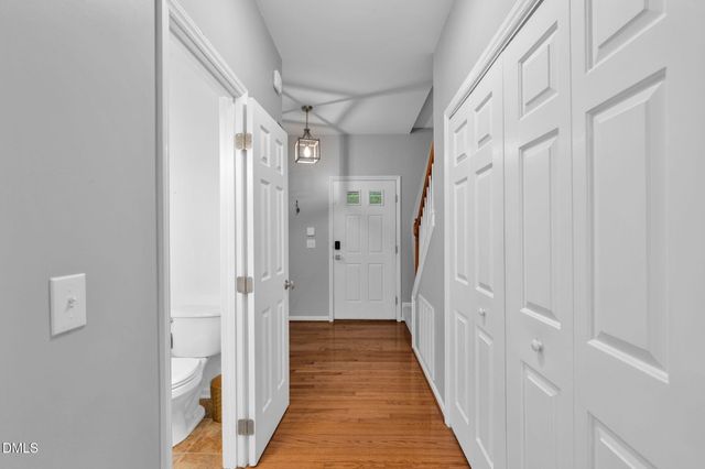 a view of a hallway with wooden floor and staircase