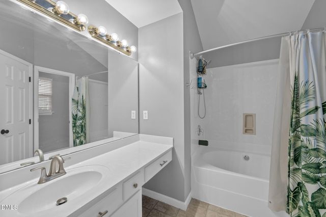 a bathroom with a tub a sink shower and a mirror