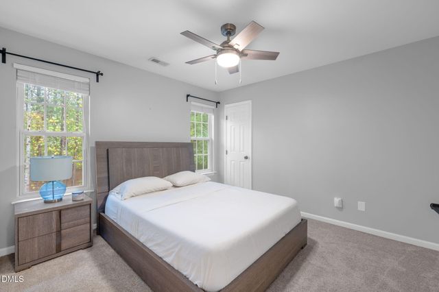 a bedroom with a large bed and a chandelier