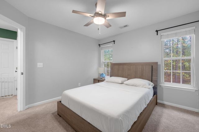 a bedroom with a large bed chandelier and a window