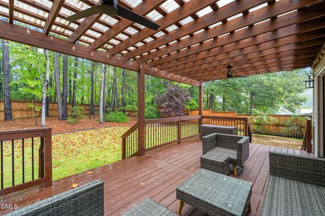 a view of a chairs and tables in the patio next to a yard