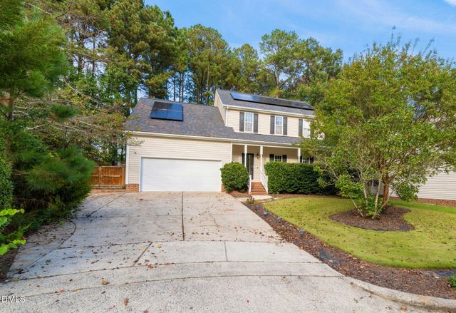 a front view of a house with a yard and trees