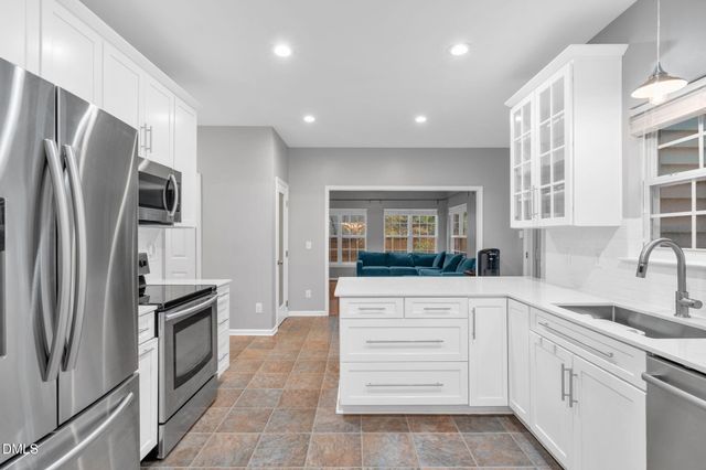 a kitchen with granite countertop stainless steel appliances and refrigerator