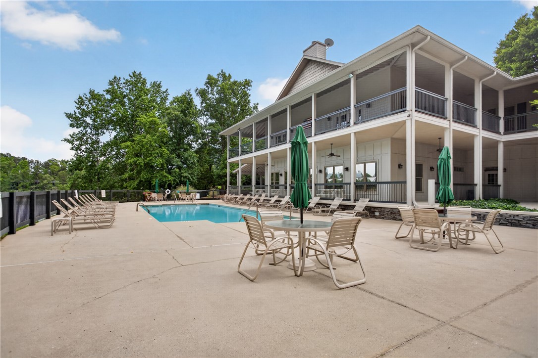 1230 Melton Road, Unit 4 West Union, SC 29696 - Photo 7 of 48 An inviting in-ground swimming pool with ample deck space for relaxation, nestled beside a multi-story recreational building.