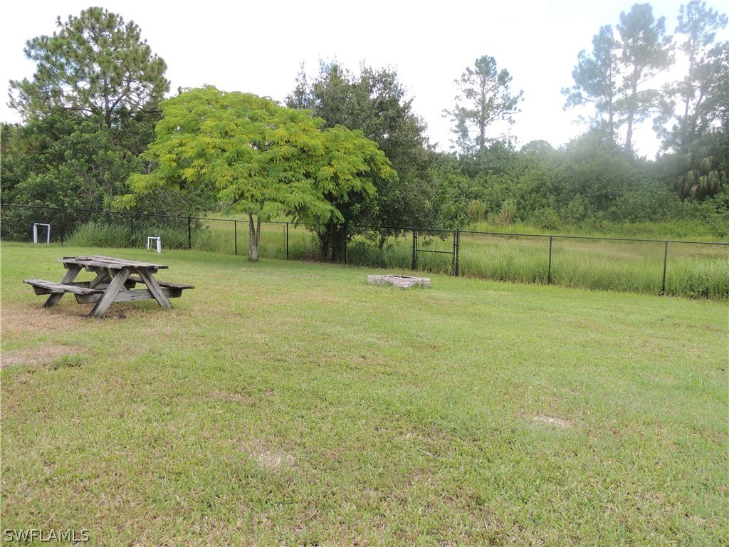 112 Ridgemont Drive Lehigh Acres, FL 33972 - Photo 17 of 18 a backyard of a house with table and chairs