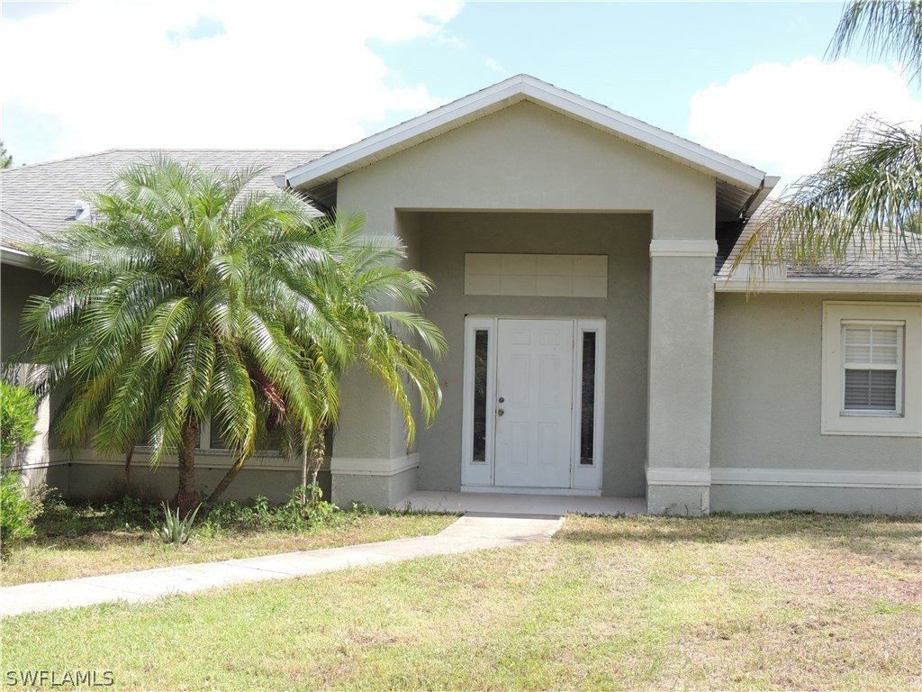 112 Ridgemont Drive Lehigh Acres, FL 33972 - Photo 18 of 18 a view of a house with a yard