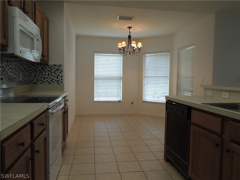 112 Ridgemont Drive Lehigh Acres, FL 33972 - Photo 5 of 18 a view of a kitchen with a sink and chandelier