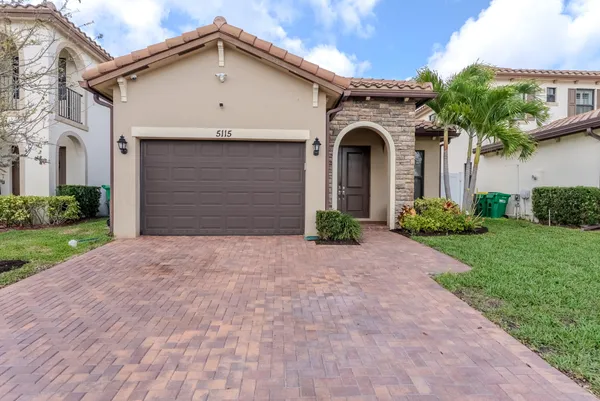 a front view of a house with a yard and garage