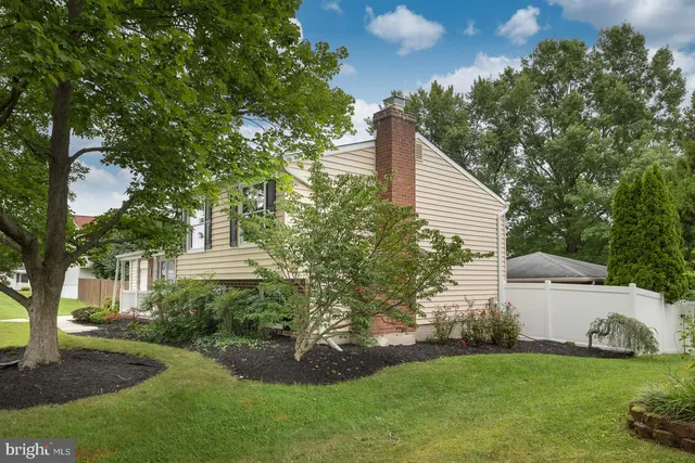 a aerial view of a house with yard and trees in the background