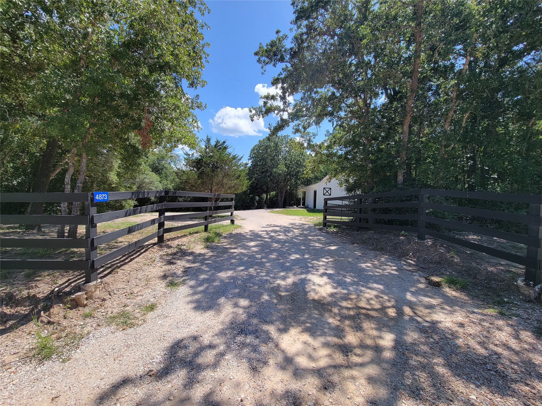 4937 Wolff Road Round Top, TX 78954 - Photo 2 of 31 Discover serenity with a gated entrance framed by majestic live oaks, offering a private retreat where nature thrives.