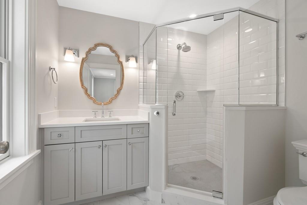 5 Stone Ridge Lane Weston, MA 02493 - Photo 23 of 40 a bathroom with a shower a mirror and a sink