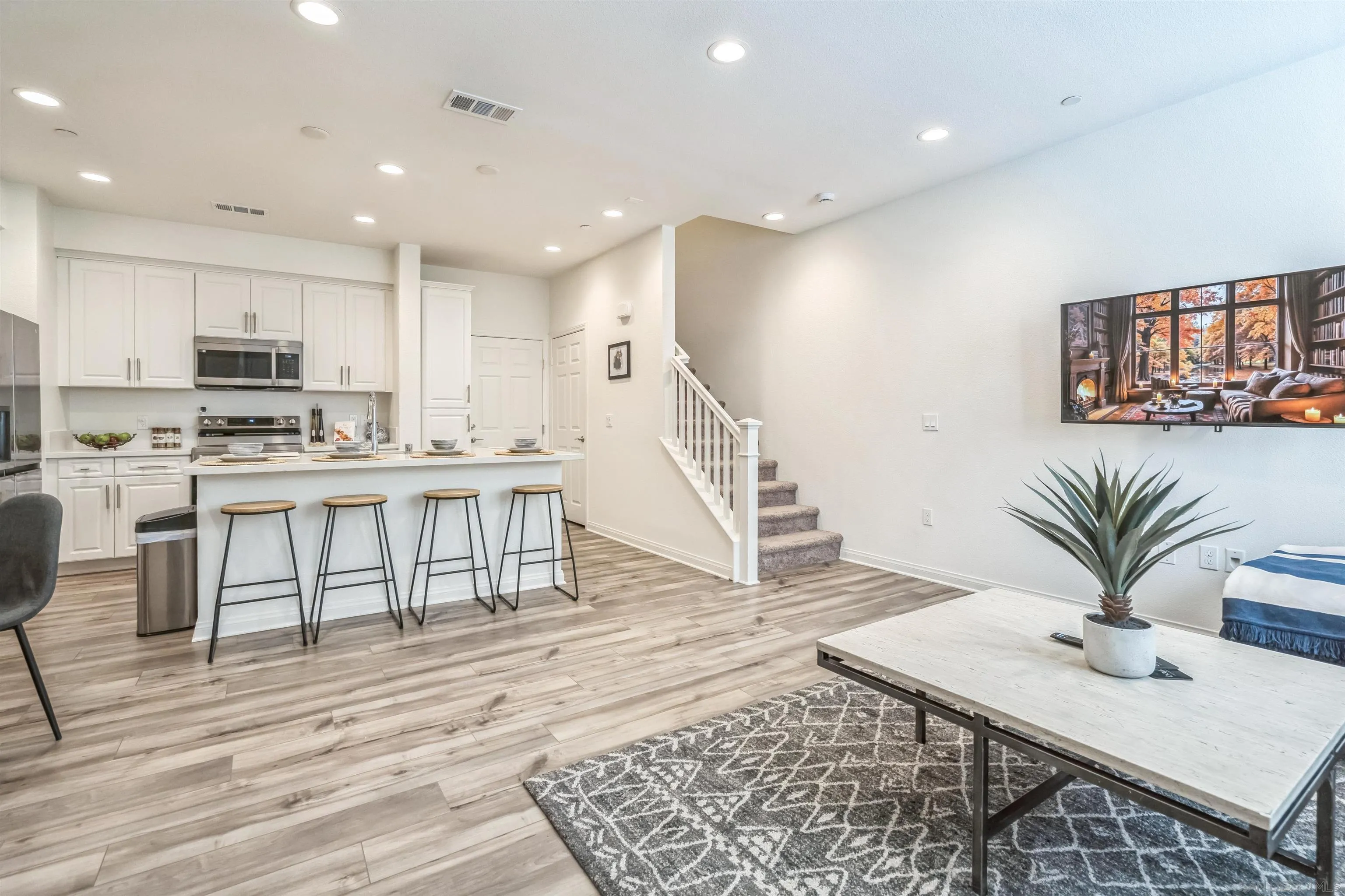 2018 Barite Street Spring Valley, CA 91977 - Photo 13 of 47 a open kitchen with stainless steel appliances kitchen island granite countertop a refrigerator a stove a sink a dining table and chairs with wooden floor