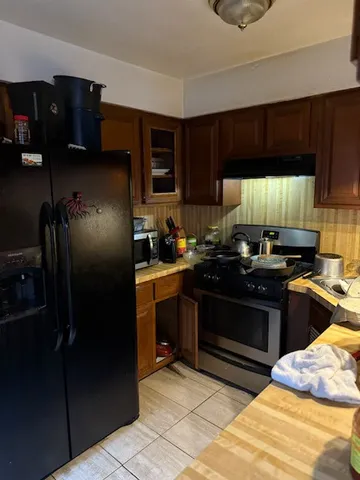 a kitchen with a refrigerator and a stove top oven