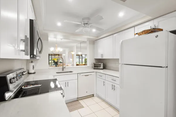 a kitchen with white cabinets and white appliances