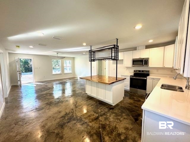 403 East 4th Street Bay Minette, AL 36507 - Photo 7 of 19 Kitchen featuring butchers block on center island, stainless steel appliances, and white cabinets with granite counter tops