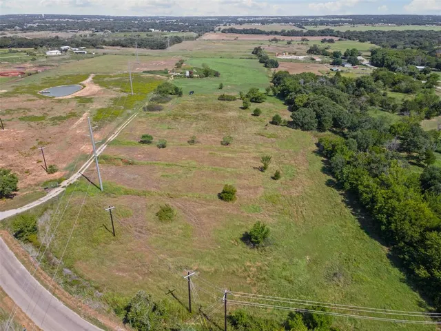 an aerial view of a house with a yard and lake view